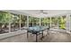 Bright game room features natural light, wood floors, and a ping pong table, perfect for entertaining guests and Gathering fun at 1857 Siesta Dr, Sarasota, FL 34239