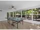Bright game room features natural light, wood floors, and a ping pong table, perfect for entertaining guests and Gathering fun at 1857 Siesta Dr, Sarasota, FL 34239