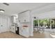 Bright and airy kitchen featuring white cabinets, modern appliances, and ample counter space leading to additional living area at 1857 Siesta Dr, Sarasota, FL 34239