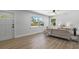 Sunlit living room featuring wood flooring, comfortable seating and windows with views of a manicured yard at 1857 Siesta Dr, Sarasota, FL 34239