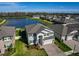 Stunning aerial view of the house with lush green lawn next to a serene lake in a vibrant community at 19293 Breynia Dr, Lutz, FL 33558