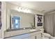 Bathroom with granite countertop, white cabinetry, large mirror, and a view to the doorway at 19293 Breynia Dr, Lutz, FL 33558