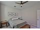 This cozy bedroom has a ceiling fan and 3 framed pictures hanging above the bed at 19293 Breynia Dr, Lutz, FL 33558