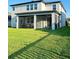 Rear exterior view of home highlighting the screened in patio with ample lawn at 19293 Breynia Dr, Lutz, FL 33558