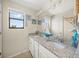 Bathroom features a dual sink vanity, ample mirror space, and a coastal decor at 19369 Nearpoint Dr, Venice, FL 34292