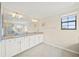 Bright bathroom featuring a double vanity with granite countertop and large mirror at 19369 Nearpoint Dr, Venice, FL 34292