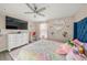 Bright bedroom with decorative heart shelf and large television on the wall at 19369 Nearpoint Dr, Venice, FL 34292