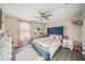 Bright bedroom features a blue headboard, ceiling fan and decor shelves at 19369 Nearpoint Dr, Venice, FL 34292