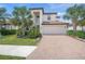 Beautiful two-story home featuring a brick driveway, attached garage, and well-manicured lawn with mature landscaping at 19369 Nearpoint Dr, Venice, FL 34292