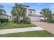 Charming two-story home featuring a brick driveway, attached garage, and well-manicured lawn with mature landscaping at 19369 Nearpoint Dr, Venice, FL 34292