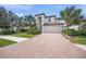 Gorgeous two-story home featuring a brick driveway, attached garage, and well-manicured lawn with mature landscaping at 19369 Nearpoint Dr, Venice, FL 34292