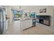 Kitchen island with granite countertop, double sinks, and an under-counter dishwasher with custom artwork at 19369 Nearpoint Dr, Venice, FL 34292
