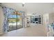 Open living room with tile flooring, a ceiling fan, a large entertainment center, and sliding glass doors to the pool at 19369 Nearpoint Dr, Venice, FL 34292