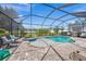 Screened in pool area with a hot tub, comfortable seating, and lush landscaping at 19369 Nearpoint Dr, Venice, FL 34292