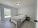 This bedroom has gray walls, wood-look floors, one window and simple black nightstands at 2122 Pleasure Run Dr, Ruskin, FL 33570