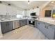 Modern kitchen featuring stainless steel appliances, gray cabinets, and a stylish backsplash at 2122 Pleasure Run Dr, Ruskin, FL 33570