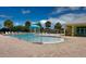 Community pool with a splash fountain feature and shaded seating, surrounded by mature palm trees at 2122 Pleasure Run Dr, Ruskin, FL 33570