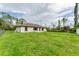 Large backyard showcasing a grassy area and the home's exterior with multiple windows at 2237 Sadnet Ln, North Port, FL 34286