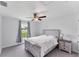 Well-lit bedroom with a window view, ceiling fan, and a cozy blanket draped over the bed at 2237 Sadnet Ln, North Port, FL 34286