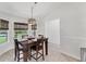 Charming dining area with a modern light fixture, a dark wood table, and sunlit windows at 2237 Sadnet Ln, North Port, FL 34286