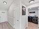 Hallway with tile floors connecting the entryway to the laundry room with modern washer and dryer units at 2237 Sadnet Ln, North Port, FL 34286