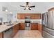 Modern kitchen featuring stainless steel appliances, granite countertops, and warm wood cabinetry at 2237 Sadnet Ln, North Port, FL 34286