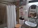 Cozy bathroom featuring a shower with curtain, pedestal sink, and decorative shelves at 2411 Quail Ct, Bradenton, FL 34209