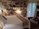 Bright bedroom with bookshelves, a comfy bed, and natural light streaming through sheer curtains at 2411 Quail Ct, Bradenton, FL 34209