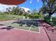 Outdoor tennis court surrounded by a green fence and trees, offering a private playing experience at 2411 Quail Ct, Bradenton, FL 34209