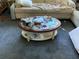 Close-up of a coffee table with an oval glass top, surrounded by plush sofas in a neutrally carpeted living room at 2617 Riverbluff Pkwy # V151, Sarasota, FL 34231