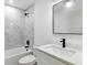 Updated bathroom with tiled shower, large mirror, black fixtures, and stone countertop at 2692 Pretzel Ln, North Port, FL 34286