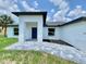 Modern home featuring a covered entryway, a paver walkway and minimalist landscaping at 2692 Pretzel Ln, North Port, FL 34286