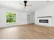 A bright living room featuring hardwood floors, a ceiling fan, and an electric fireplace at 2692 Pretzel Ln, North Port, FL 34286