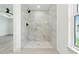 Walk-in shower featuring marble-look tile walls and floor, with a modern shower head at 2692 Pretzel Ln, North Port, FL 34286