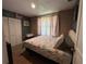 Bright bedroom featuring a full bed, closet, and a serene window, with white furniture and floral-patterned bedding at 2804 11Th Street E Ct, Bradenton, FL 34208