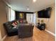 Comfortable living room featuring a leather sectional sofa, a modern TV, and neutral-colored walls with tiled flooring at 2804 11Th Street E Ct, Bradenton, FL 34208