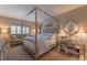 This spacious bedroom has a modern, four-poster bed and sitting area at 3401 54Th W Dr # 201, Bradenton, FL 34210