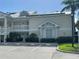 Condo exterior showcases a two-story facade, white railings, lush landscaping, and convenient parking at 3401 54Th W Dr # 201, Bradenton, FL 34210