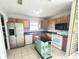 Well-lit kitchen with stainless steel refrigerator, center island and wooden cabinetry at 3526 Southern W Pkwy, Bradenton, FL 34205