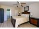 Bedroom with wood-look flooring, ceiling fan, and bathroom with shower featuring tile surround at 3539 59Th W Ave # 3539, Bradenton, FL 34210