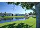 Community pond with grassy lawn and shady tree at 3539 59Th W Ave # 3539, Bradenton, FL 34210