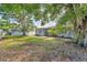 Spacious backyard with mature trees, a white privacy fence, and a glimpse of the house's exterior at 401 N Jefferson Ave, Sarasota, FL 34237