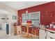 Cozy eat-in kitchen nook features a charming red accent wall, white countertops and cabinetry at 401 N Jefferson Ave, Sarasota, FL 34237