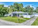 Charming single-story home with a well-manicured lawn, palm tree, and a white picket fence at 401 N Jefferson Ave, Sarasota, FL 34237