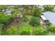 Large backyard featuring mature trees, fire pit, garden beds, and outdoor shed at 408 67Th W Ave, Bradenton, FL 34207