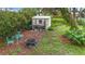 Landscaped backyard with a fire pit, shed, and an outdoor seating area at 408 67Th W Ave, Bradenton, FL 34207