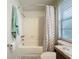 Bathroom features a white tiled shower and tub, a shower curtain, and a window with blinds at 408 67Th W Ave, Bradenton, FL 34207