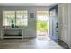 Bright foyer features stylish wood-look floors, a blue front door, and a side table with plants, creating a welcoming entrance at 408 67Th W Ave, Bradenton, FL 34207