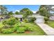 Inviting single-story home features a manicured front yard with lush landscaping, an attached garage, and a quaint walkway to the entry at 408 67Th W Ave, Bradenton, FL 34207