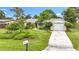 Cozy single-story home boasts a well-maintained lawn and landscaping, plus an attached garage and a welcoming walkway to the entrance at 408 67Th W Ave, Bradenton, FL 34207